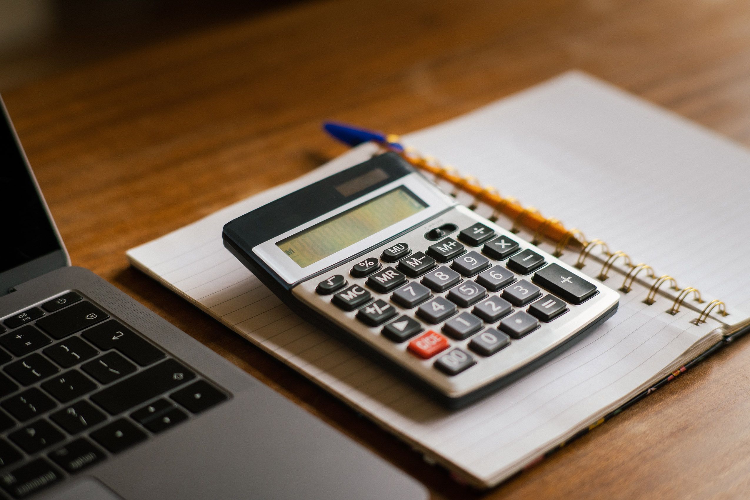 Calculator and laptop on a desk for business accounting and expense tracking