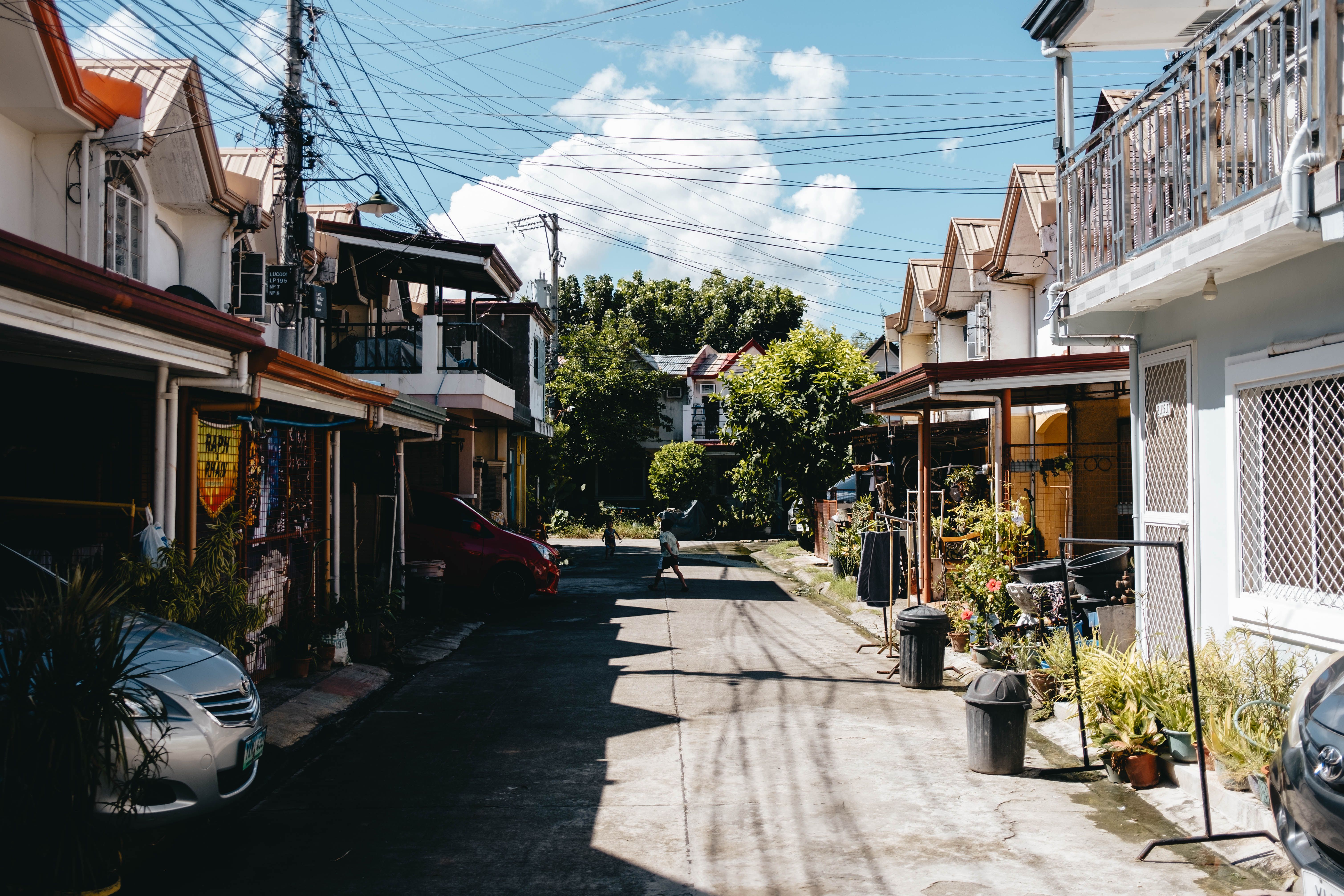 A charming neighborhood street with traditional houses on a sunny day, representing local community issues that shape voting.