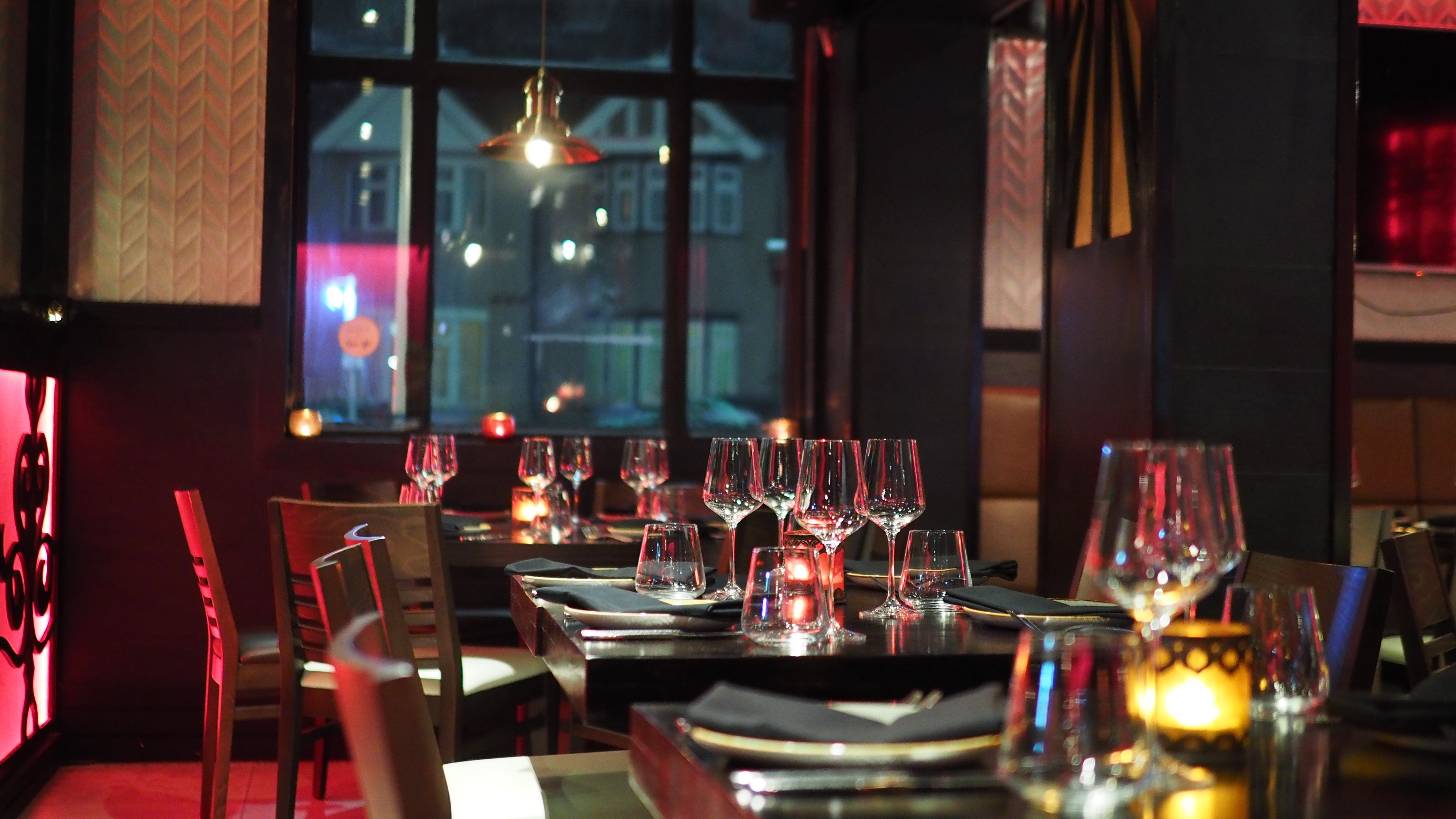 Elegant restaurant interior with candlelit tables, evoking the atmosphere of a special date night.