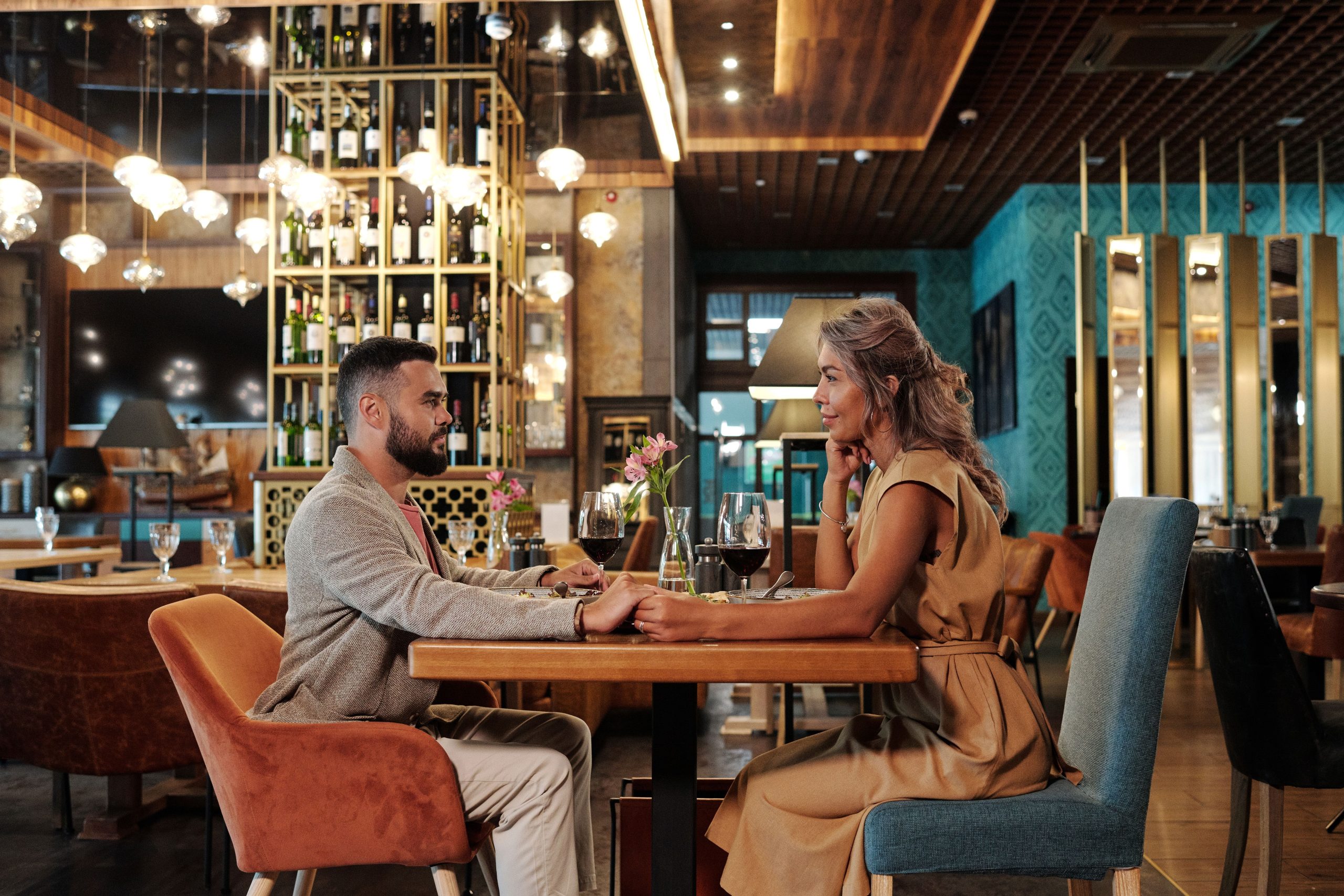 Couple enjoying a romantic dinner with wine in an elegant restaurant, illustrating the intimate atmosphere of a thoughtfully planned date.