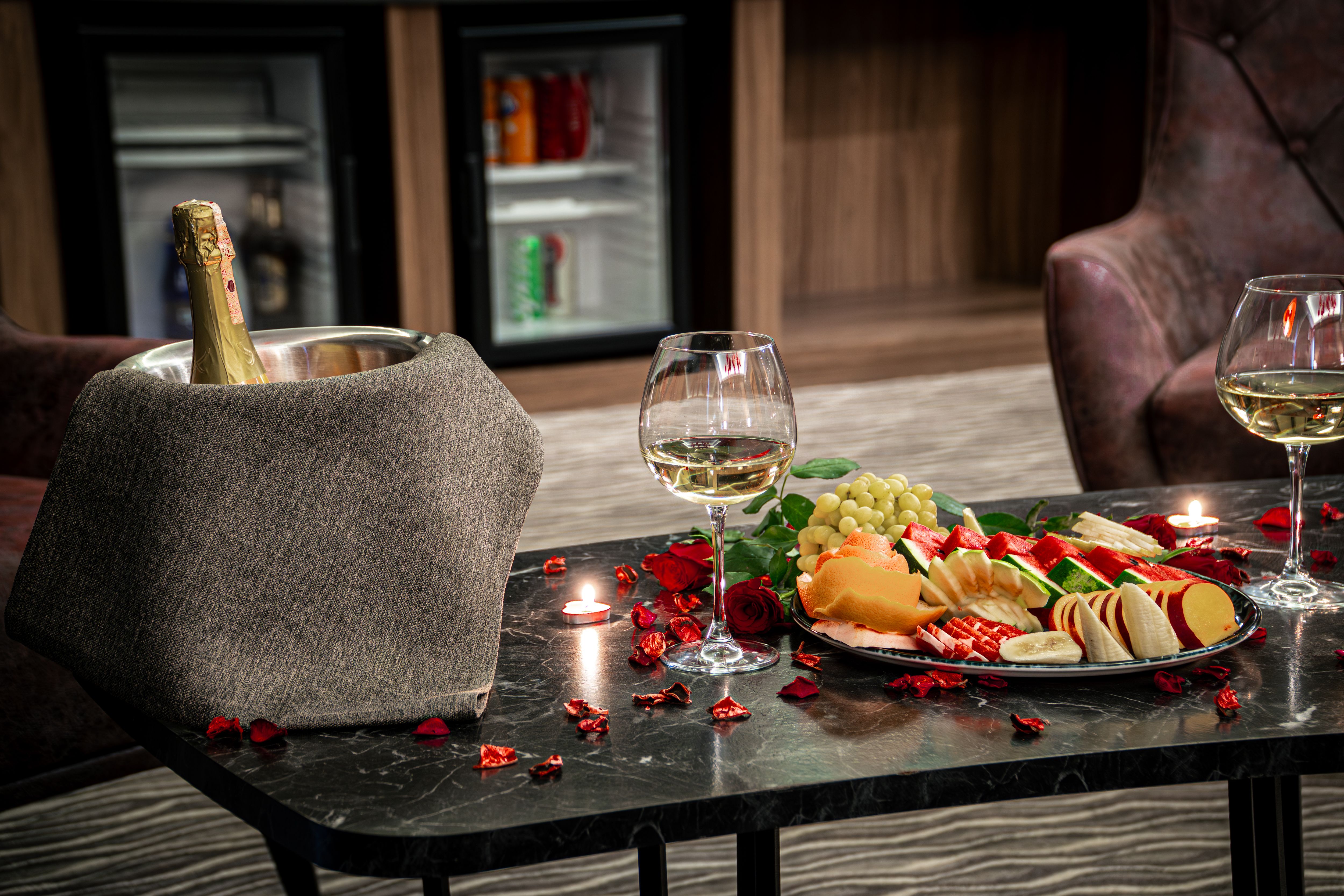 A hotel room prepared with wine glasses and a fruit plate, showing how thoughtful details can elevate a romantic stay.